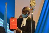 The Director Legal Affairs holding the constituion of Kenya 2010 during the Installation process of Prof. KIama